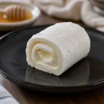 A single roll of rulo kaymak on a plate, clearly showing the dairy product.