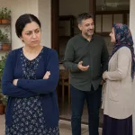A married woman looking jealous while watching her husband interact with another woman.