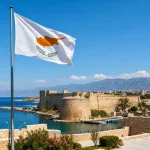 Cyprus flag with Mediterranean coast and castle landmark.
