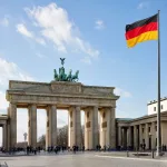 German flag with Brandenburg Gate in Berlin.