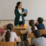 Teacher actively teaching students in a classroom.
