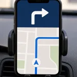 A phone navigation app in a car holder showing a clear right-turn instruction.
