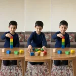 A child builds the same block tower again after it fell.